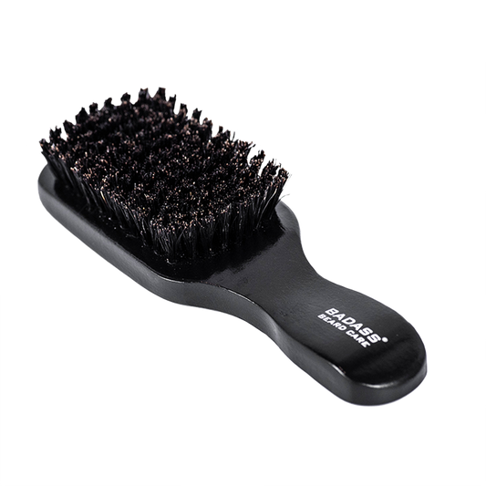 Black boar hair beard brush with handle by Badass Beard Care for grooming and detangling facial hair.
